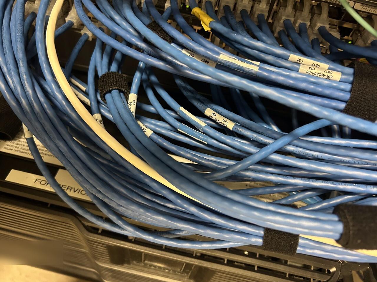 Onsite service photo showing equipment cabinet cabling and switch handoff at the server-room handoff point