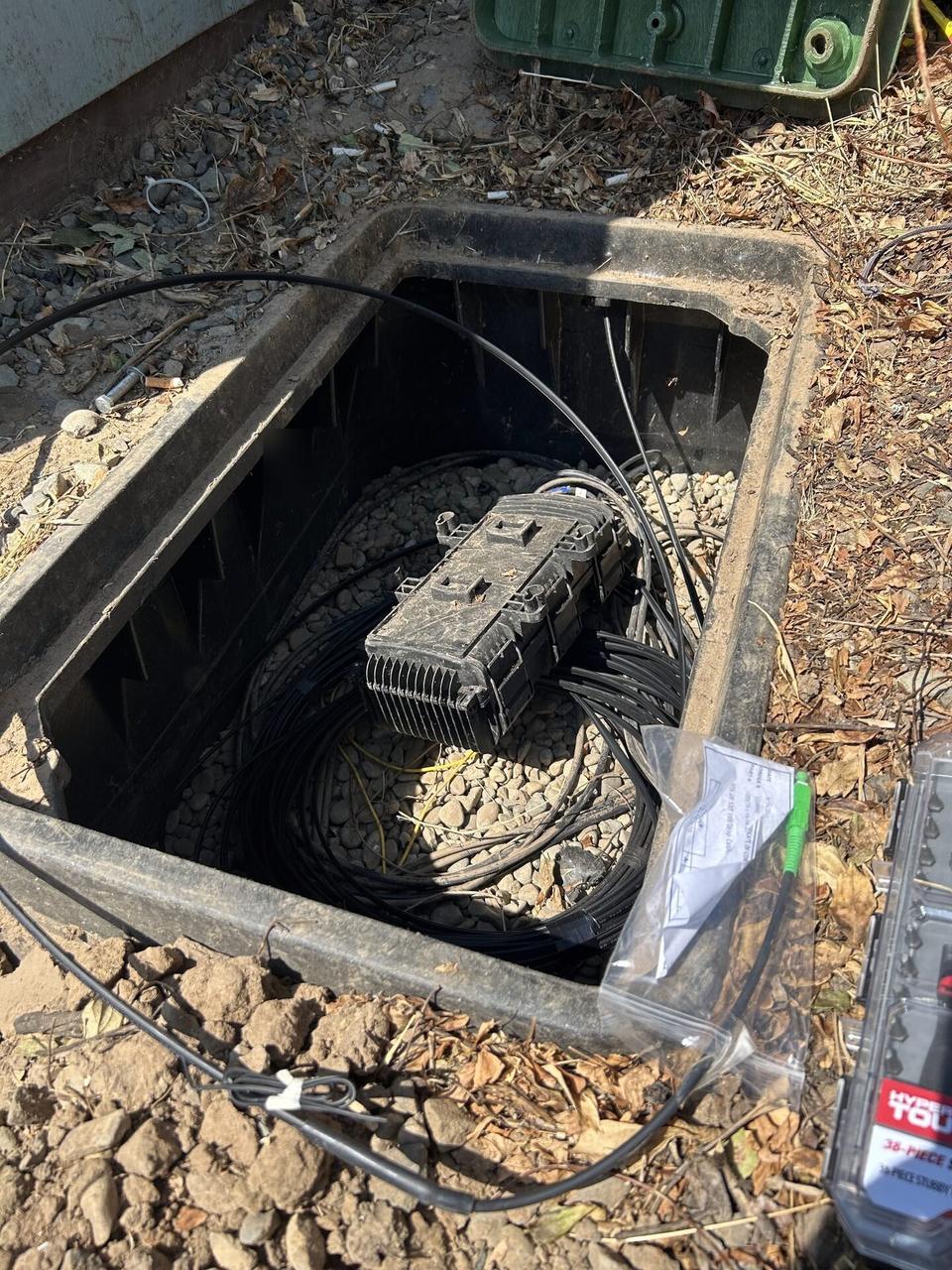 Onsite service photo showing outdoor fiber distribution unit for customer drops with cable handling visible