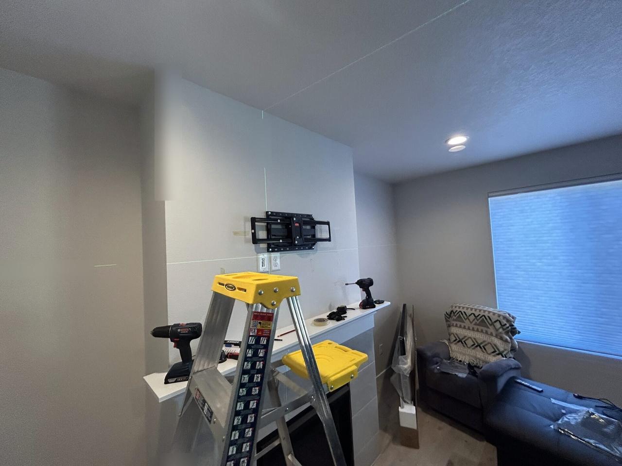 Service documentation showing wall-mounted TV setup and cable routing near the mounting location