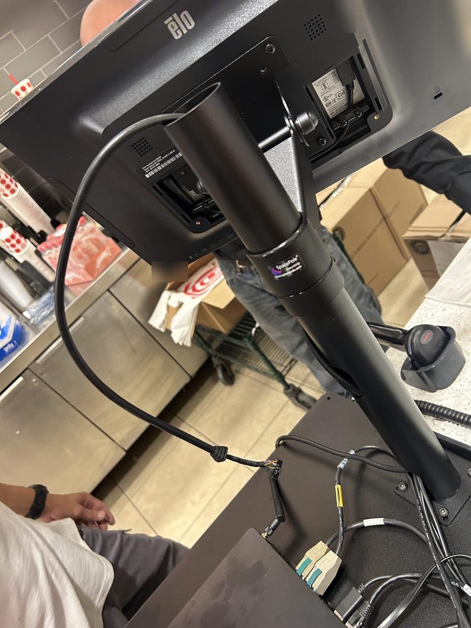 Checkout station POS hardware with cable routing visible during an Alrty onsite service visit