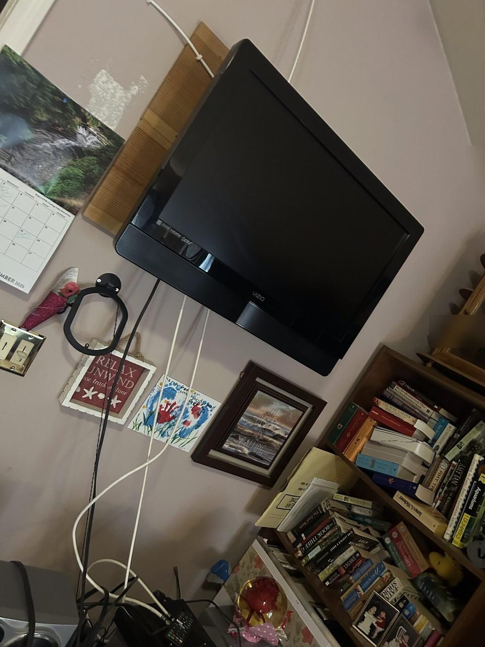 TV mounting or home theater setup detail with display placement, mount work, cabling or finished installation context