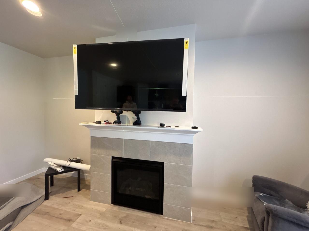 Smart technology service detail: wall-mounted TV setup and cable routing during TV service preparation