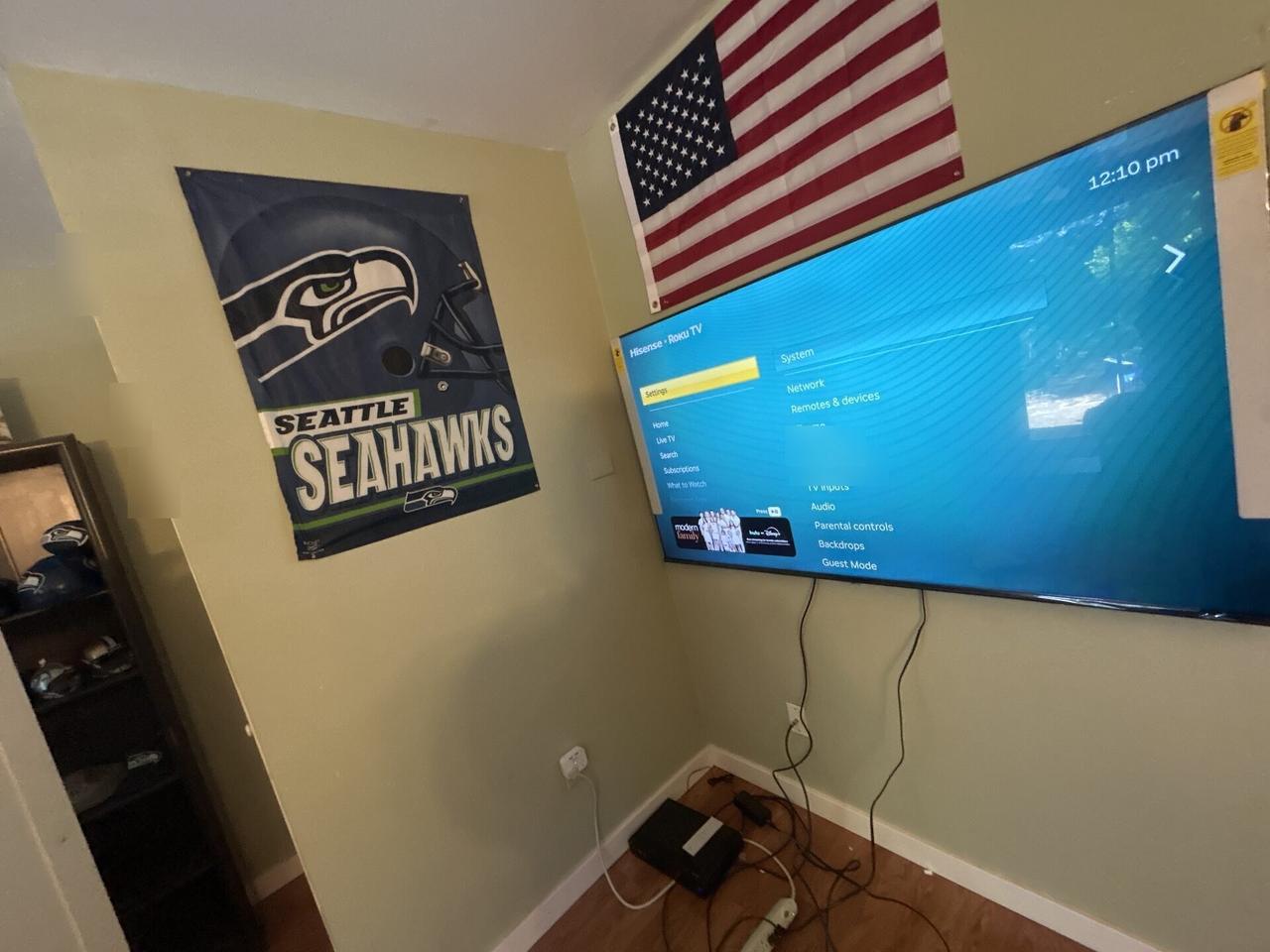 Smart technology service detail: TV mounting and display setup work with wall hardware context